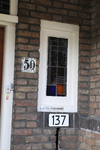 909260 Afbeelding van het glas-in-lood venster naast de voordeur en het huisnummerbordje 137 van het huis Jan van ...